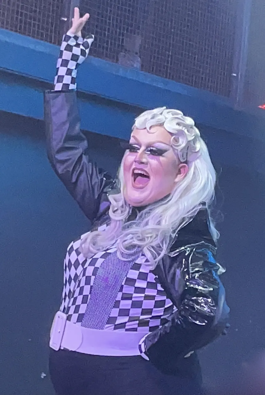 Lawrence Chaney smiling and raising one arm during a live performance