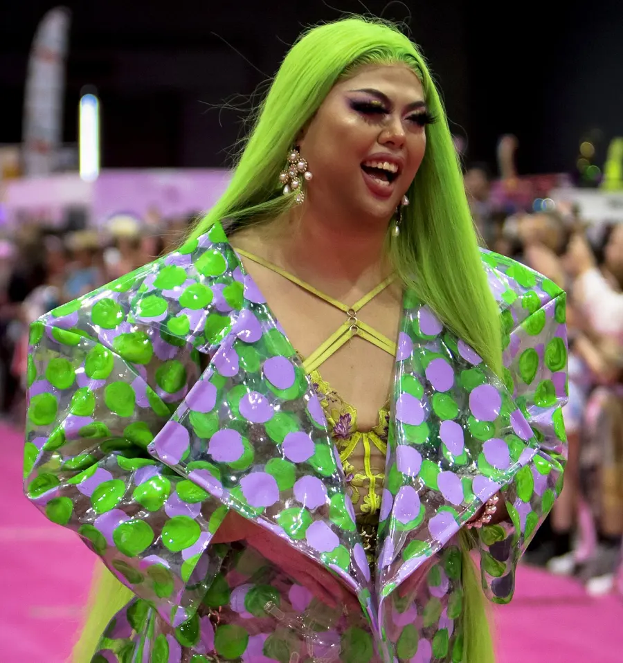 Sum Ting Wong smiling in a green and lilac drag look at DragCon