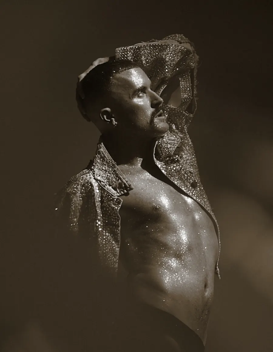 Tom Aspaul posing in a sparkling stage outfit